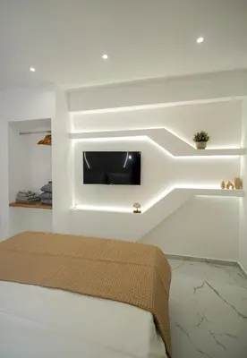 a bedroom with a bed with a tv on the wall at Athens City-Break Studios- near Acropolis in Athens