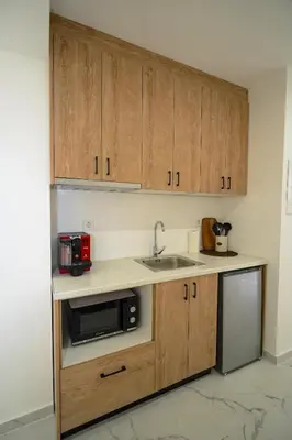 a kitchen with wooden cabinets and a sink and a microwave at Athens City-Break Studios- near Acropolis in Athens