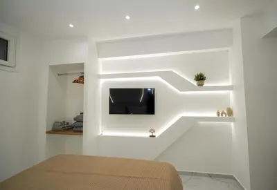a bedroom with a bed and a tv on a wall at Athens City-Break Studios- near Acropolis in Athens