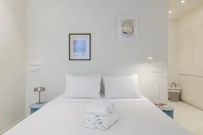 a bedroom with a white bed with towels on it at Ivory - Studio in Thisseio in Athens