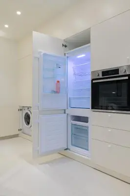 a white kitchen with an open refrigerator at Ivory - Studio in Thisseio in Athens
