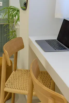 a desk with a laptop and a wooden chair at Ivory - Studio in Thisseio in Athens