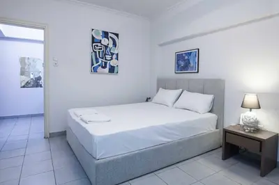 a bedroom with a large white bed and a table at Modern Studio Stay in Trendy Kolonaki in Athens