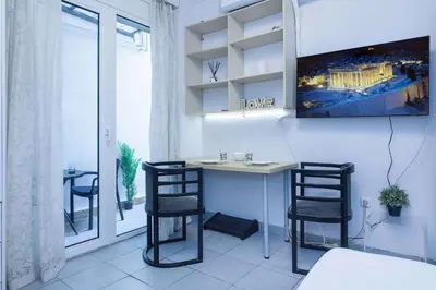 a room with a desk with two chairs and a tv at Modern Studio Stay in Trendy Kolonaki in Athens