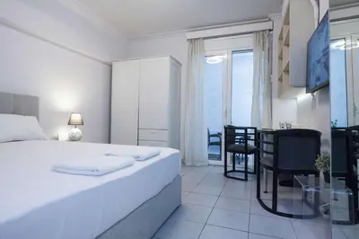 a white bedroom with a bed and a dining room at Modern Studio Stay in Trendy Kolonaki in Athens