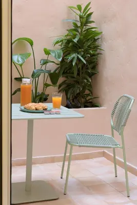 a table and a chair with a plate of food and orange juice at Ciel - Studio in Thisseio in Athens