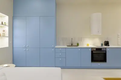 a kitchen with blue cabinets and white appliances at Ciel - Studio in Thisseio in Athens