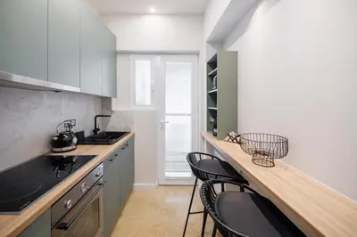a kitchen with a counter with stools in it at Luxurious Apartment at Hilton Area in Athens