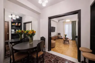a dining room with a table and a living room at Luxurious Apartment at Hilton Area in Athens