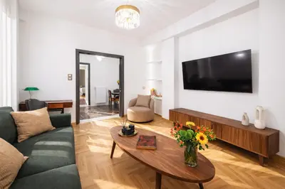 a living room with a couch and a table with flowers at Luxurious Apartment at Hilton Area in Athens