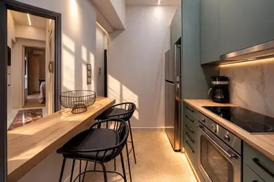 a kitchen with three chairs at a counter in a kitchen at Luxurious Apartment at Hilton Area in Athens
