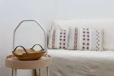 a bowl on a stand next to a bed at Lilly's House in Athens