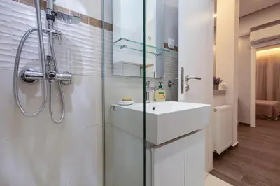 a white bathroom with a sink and a shower at Lilly's House in Athens