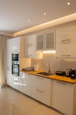 a kitchen with white cabinets and a sink at E35 by SpitiSou in Athens