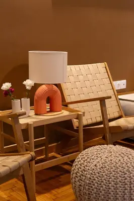 a living room with a table with a lamp and a chair at E35 by SpitiSou in Athens