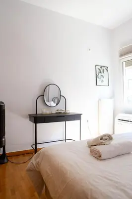 a bedroom with a bed and a table with a mirror at E35 by SpitiSou in Athens