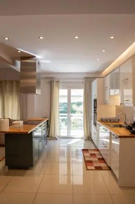 a kitchen with white cabinets and a large window at E35 by SpitiSou in Athens