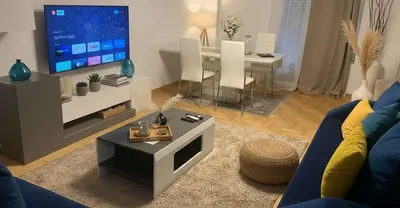 a living room with a blue couch and a tv at The Exarcheia Nook Chic Renovated 2BR Apartment in Athens
