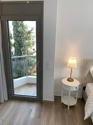 a room with a large window and a table with a lamp at My Seaview & Beach home in Athens