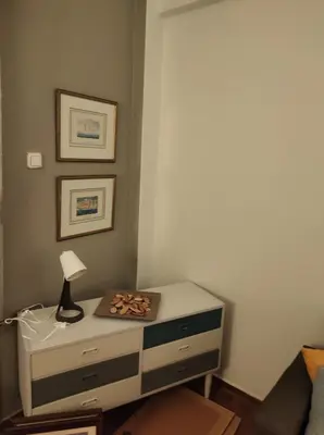a dresser with a lamp on it in a room at Kornilis apartment near the historical center in Athens