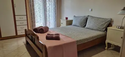 a bedroom with a bed with a pink blanket at FarmHouse near Airport in Paianía