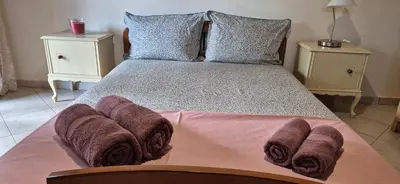 a bed with brown blankets and pillows on it at FarmHouse near Airport in Paianía