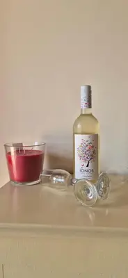 a bottle of wine and a bowl on a table at FarmHouse near Airport in Paianía