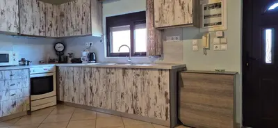 a kitchen with wooden cabinets and a sink at FarmHouse near Airport in Paianía