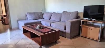 a living room with a couch and a coffee table at FarmHouse near Airport in Paianía