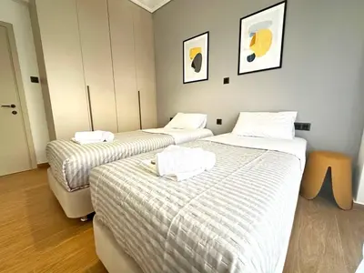 a room with two beds with white sheets at 4th Floor Bright 2BR Retreat Near Acropolis in Athens