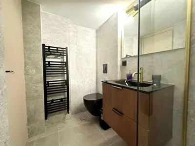 a bathroom with a black toilet and a sink at 4th Floor Bright 2BR Retreat Near Acropolis in Athens