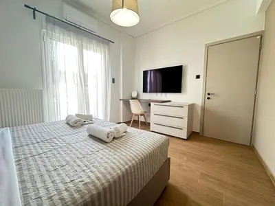 a bedroom with a bed and a desk and a television at 4th Floor Bright 2BR Retreat Near Acropolis in Athens