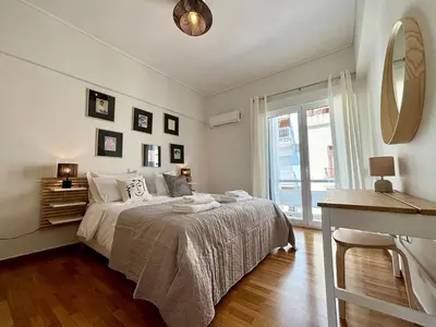 a white bedroom with a bed and a mirror at Cozy apartment in Kolonaki in Athens