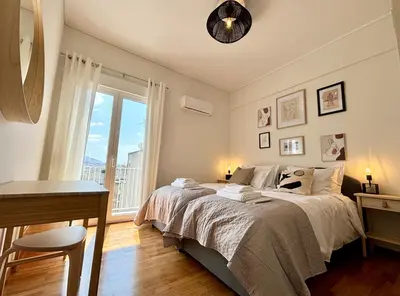 a bedroom with a bed and a desk and a window at Cozy apartment in Kolonaki in Athens