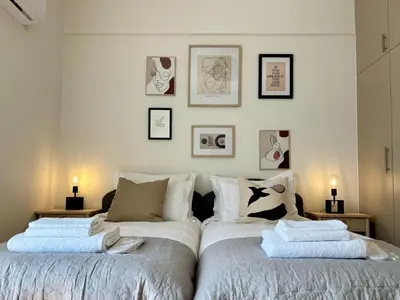 two beds sitting next to each other in a bedroom at Cozy apartment in Kolonaki in Athens