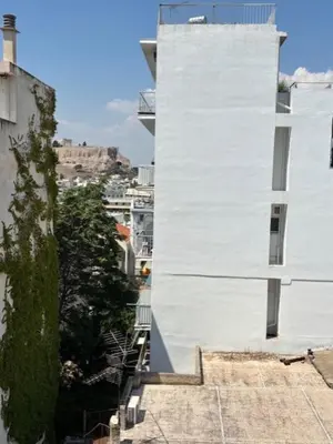 a white building with a cross on the side of it at mets in Athens