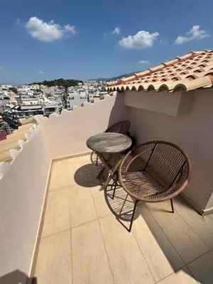 a patio with a chair and a table on a balcony at mets in Athens