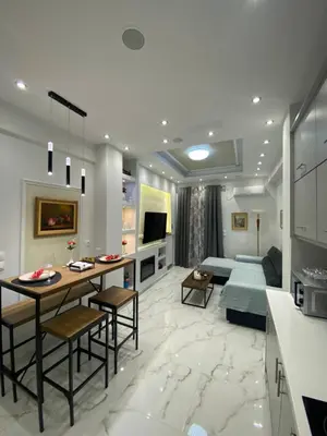 a kitchen and living room with a table and a couch at Golden Nest Apartment in Athens
