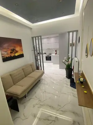 a living room with a couch on a marble floor at Golden Nest Apartment in Athens