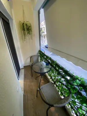 a balcony with two chairs and a table in a building at Golden Nest Apartment in Athens