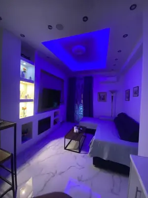 a purple living room with a couch and a tv at Golden Nest Apartment in Athens