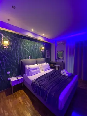 a bedroom with a large bed with purple lighting at Golden Nest Apartment in Athens