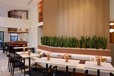 a restaurant with tables and chairs and plants at Bellén Athens Ηotel in Athens