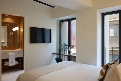 a bedroom with a bed and a television on a wall at Bellén Athens Ηotel in Athens