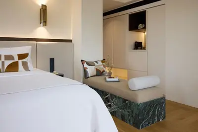 a bedroom with a white bed and a chair at Bellén Athens Ηotel in Athens