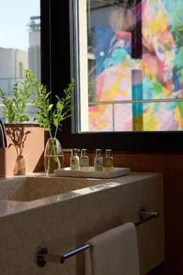 a bathroom sink with a towel and a window at Bellén Athens Ηotel in Athens