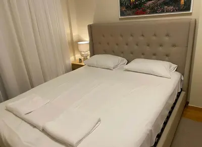 a bedroom with a large bed with white sheets and pillows at Acropolis Vista 3-Bedroom in Neos Kosmos in Athens