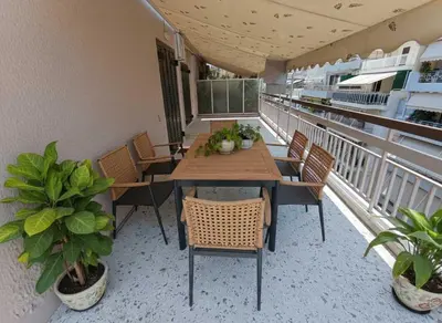 a table and chairs on a balcony with plants at Acropolis Vista 3-Bedroom in Neos Kosmos in Athens