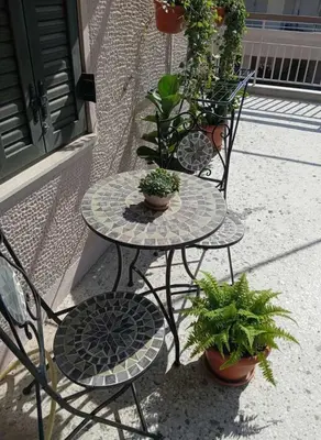 a table and two chairs with potted plants on it at Acropolis Vista 3-Bedroom in Neos Kosmos in Athens
