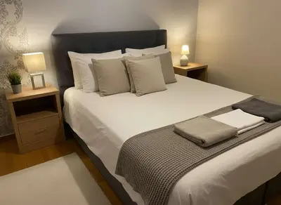 a bedroom with a large white bed with two night stands at The Athenian Nest 2-Bedroom Apartment in Metaxou in Athens